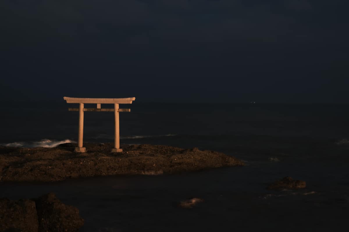 神磯鳥居夜間景色,暖光照射下的石造鳥居與夜色海面