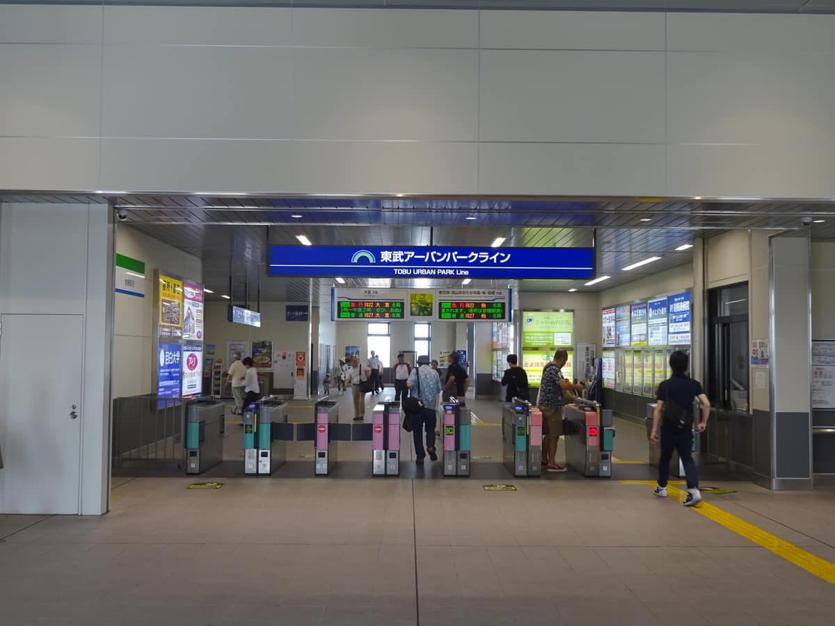 The Tobu Urban Park Line ticket gates at Iwatsuki Station, with passengers passing through