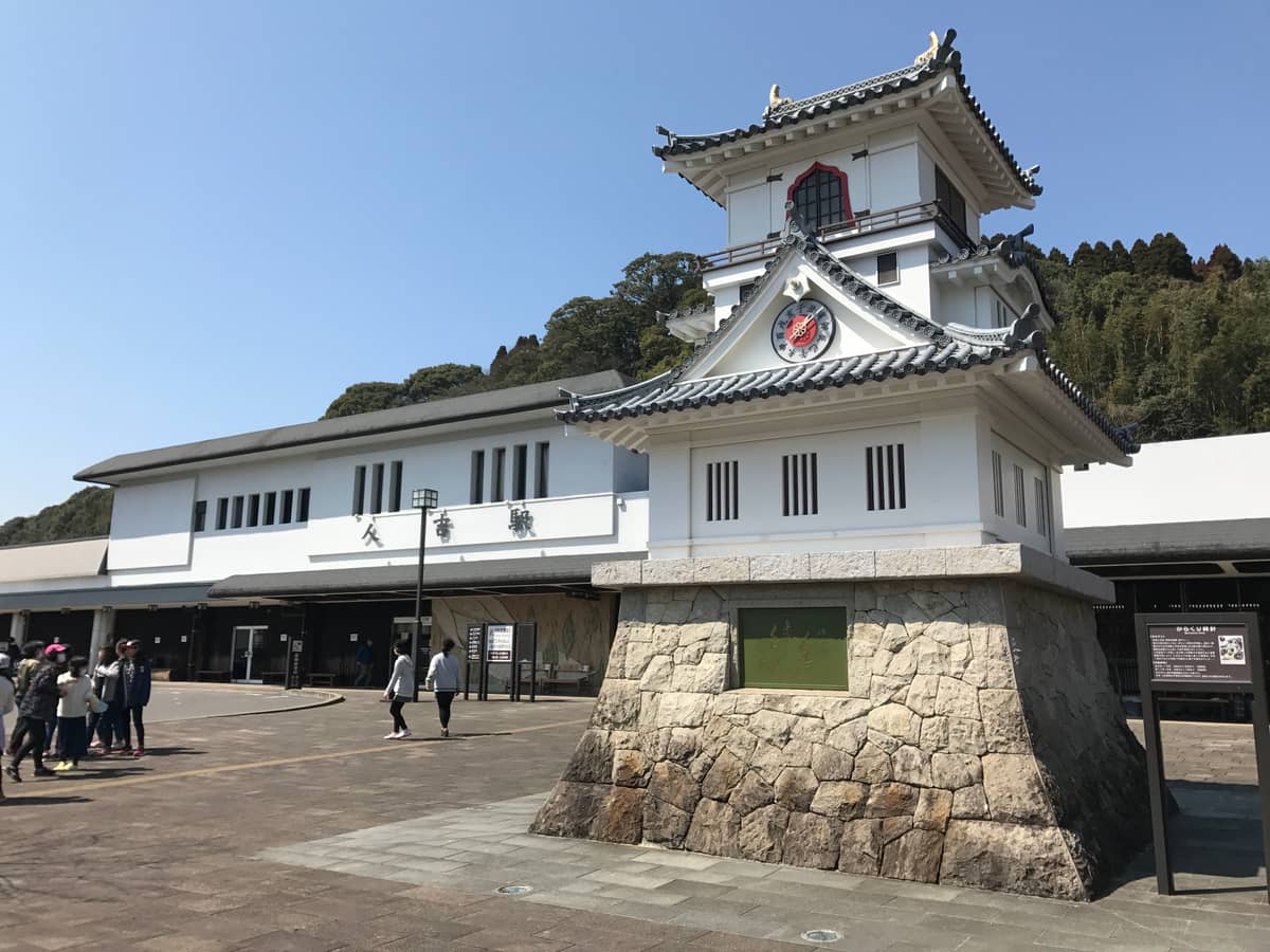 人吉站城樓造型站體與鐘樓,站前廣場遊客往來