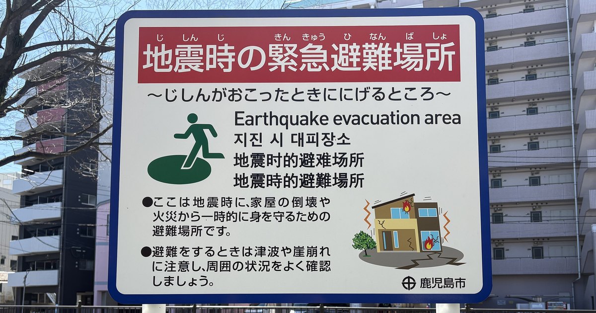 A Japanese street sign marking an earthquake evacuation area, labelled in five languages including English and Traditional Chinese