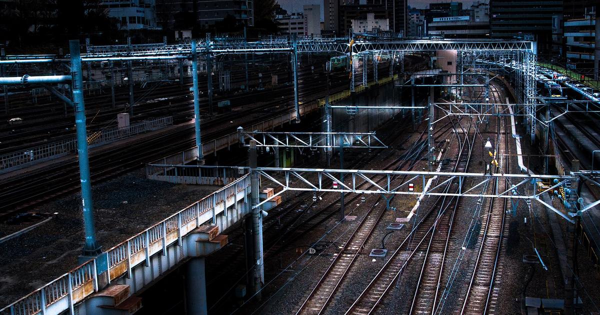 Ueno station's track fan seen from above late at night, rails and overhead wires lit but empty of trains