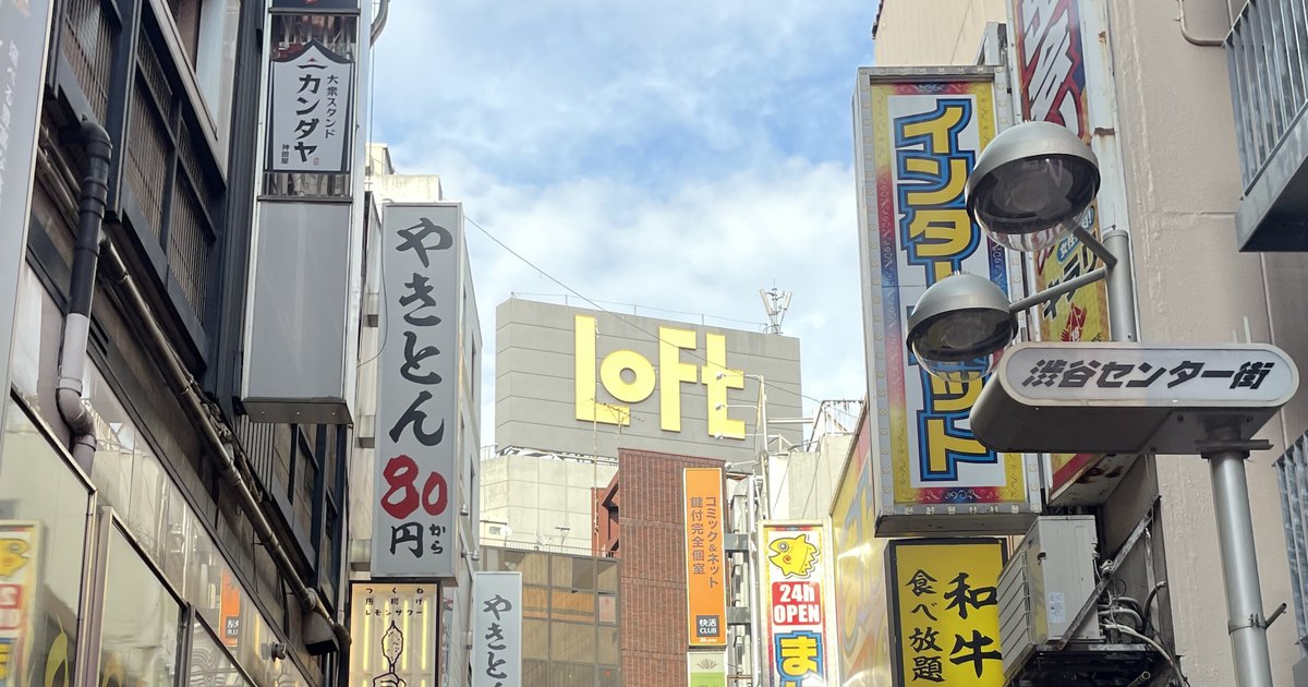 Looking up along Shibuya Center-gai: vertical shop signs on both sides, the yellow LOFT lettering on the rooftop of the building at the end, and a street-lamp sign reading 渋谷センター街