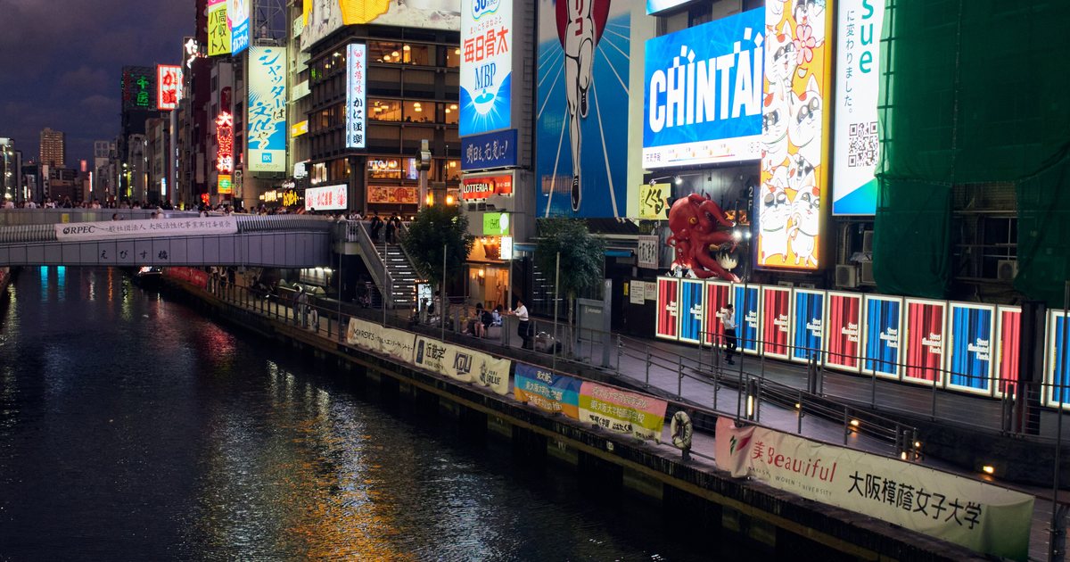 Neon signs reflected in the Dotonbori canal in Osaka at night, where New Year crowds gather without any official organiser