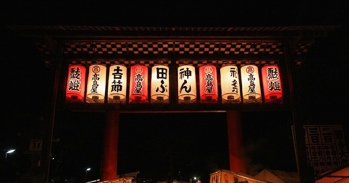 Torii of Yoshida Shrine in Kyoto on Setsubun night, hung with paper lanterns reading Setsubun and Yakuyoke above rows of food stalls and crowds