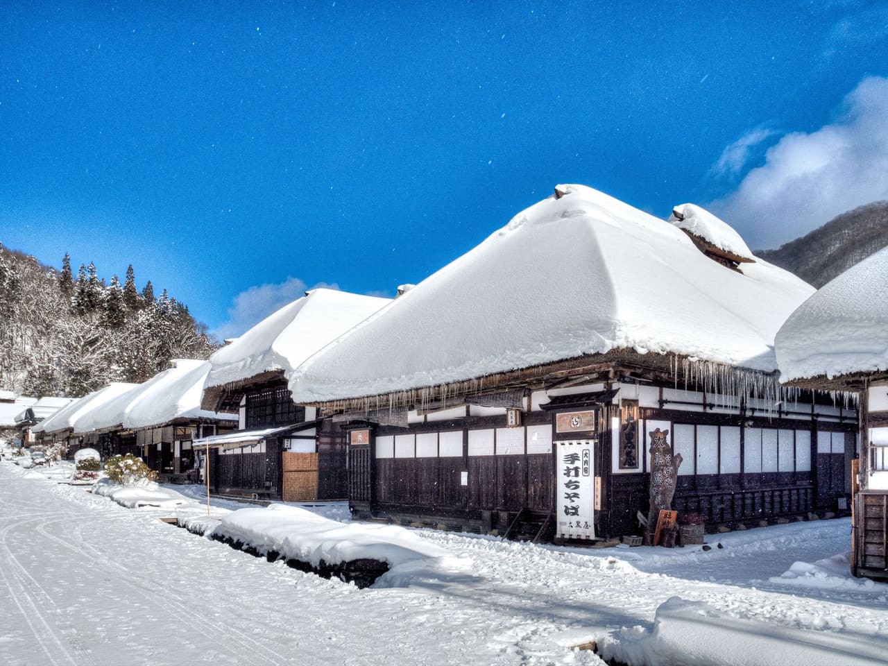 大內宿冬季雪景，茅葺屋頂積著厚雪的老街
