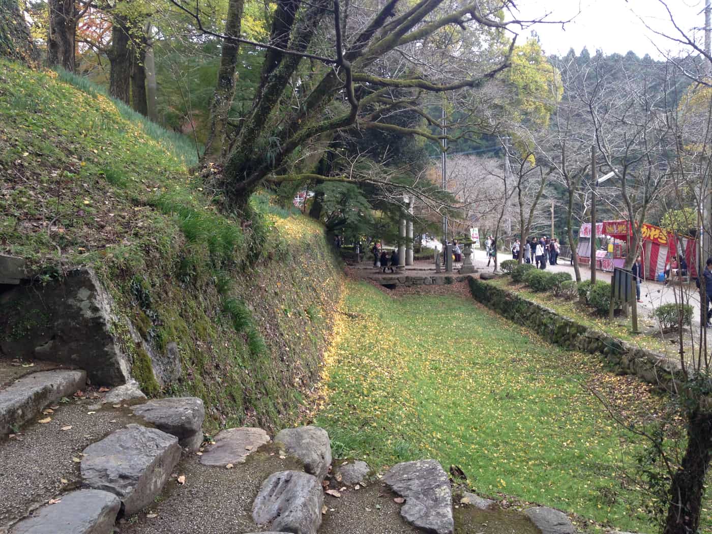 The dry moat (karabori) at Akizuki Castle ruins, an empty earthwork trench beside the stone walls