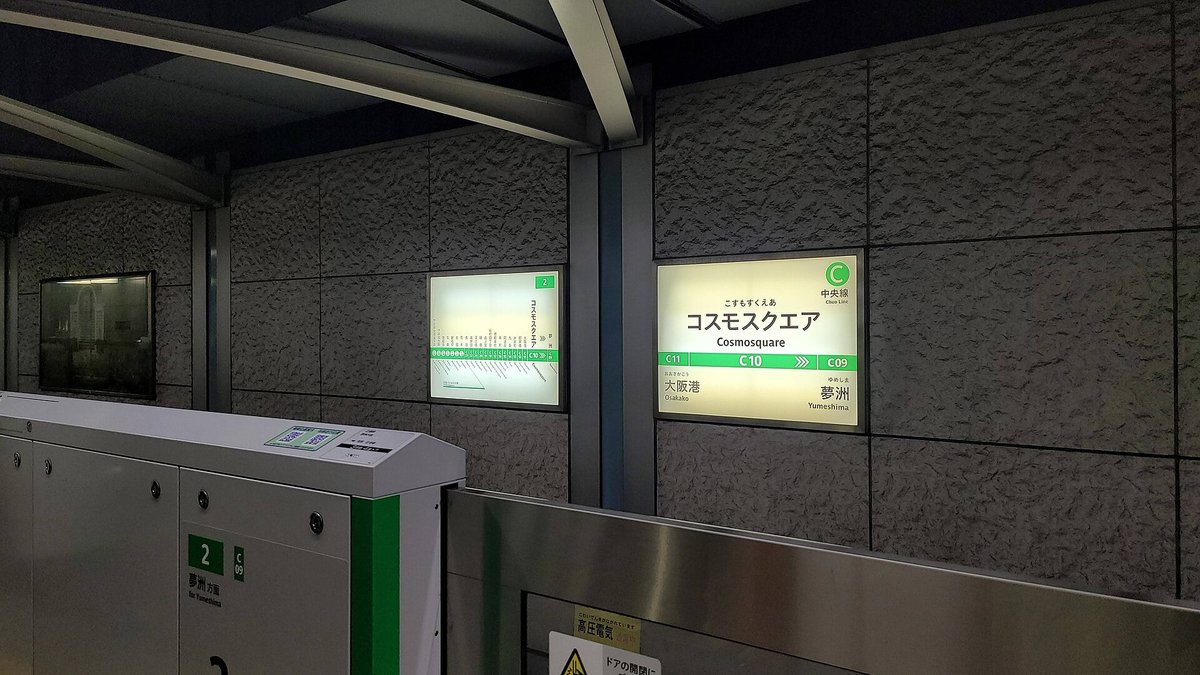 大阪メトロ中央線コスモスクエア站月台的綠色站名牌,站號 C10,左邊一站是大阪港 C11,右邊下一站是夢洲 C09;前景是月台閘門,標著 2 號線夢洲方面