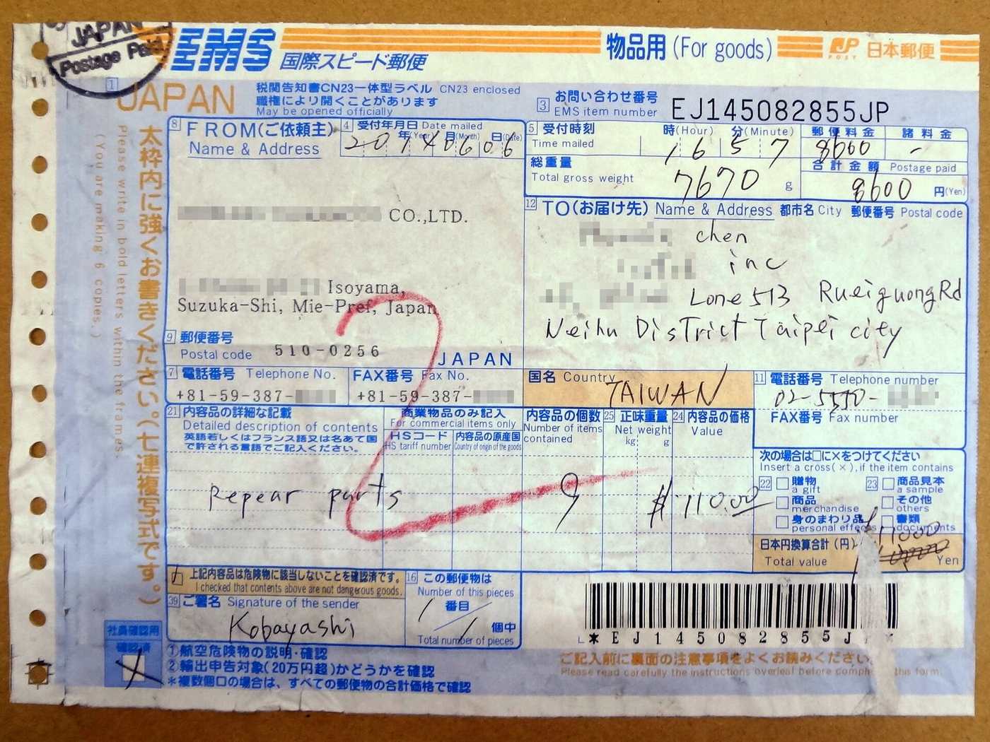 A completed Japan Post EMS label stuck to a brown carton: blue printed form with EMS branding across the top and an orange For goods marker, a JAPAN Postage Paid handstamp and the item number EJ145082855JP at upper right, a company sender address in Suzuka, Mie Prefecture, a handwritten English delivery address in Neihu District, Taipei with TAIWAN written in the country box, 8600 written in the postage box and 7670 grams in the gross weight box, and a long barcode with the sender signature along the bottom