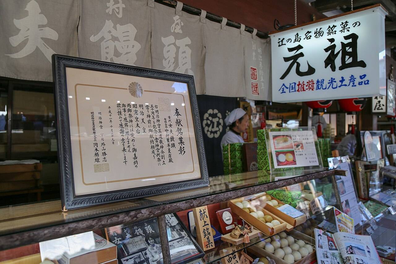 中村屋羊羹店的店頭，「江の島名物銘菓の元祖」看板、明治神宮奉獻銘菓彰狀與玻璃櫃內的和菓子