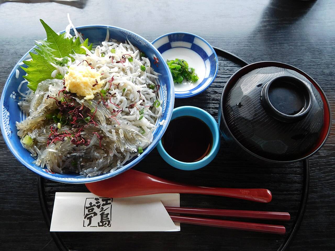 江之島當地店家的生しらす丼，碗中鋪滿生魩仔魚，配紫蘇、薑蓉與蔥花