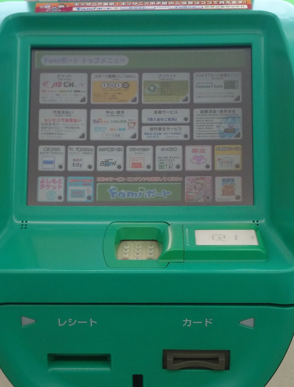 Close-up of an older FamilyMart Fami-Port terminal: the touchscreen header reads Fami-Port top menu, and in the grid of buttons the second one on the left is the payment button, captioned in red as paying at the convenience store, with small print below listing bill collection, various payments, reserved-item pickup and Amazon multi-payment; a numeric keypad and a reader window sit under the screen, and the lower front edge is marked receipt on the left and card on the right