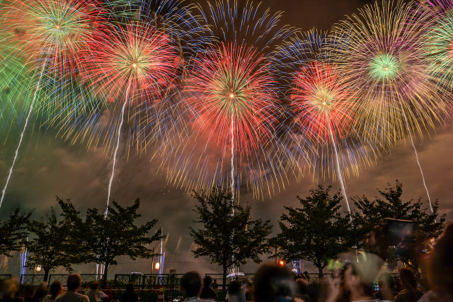 日本花火大會夜空遠景——觀眾席與河岸的浴衣身影