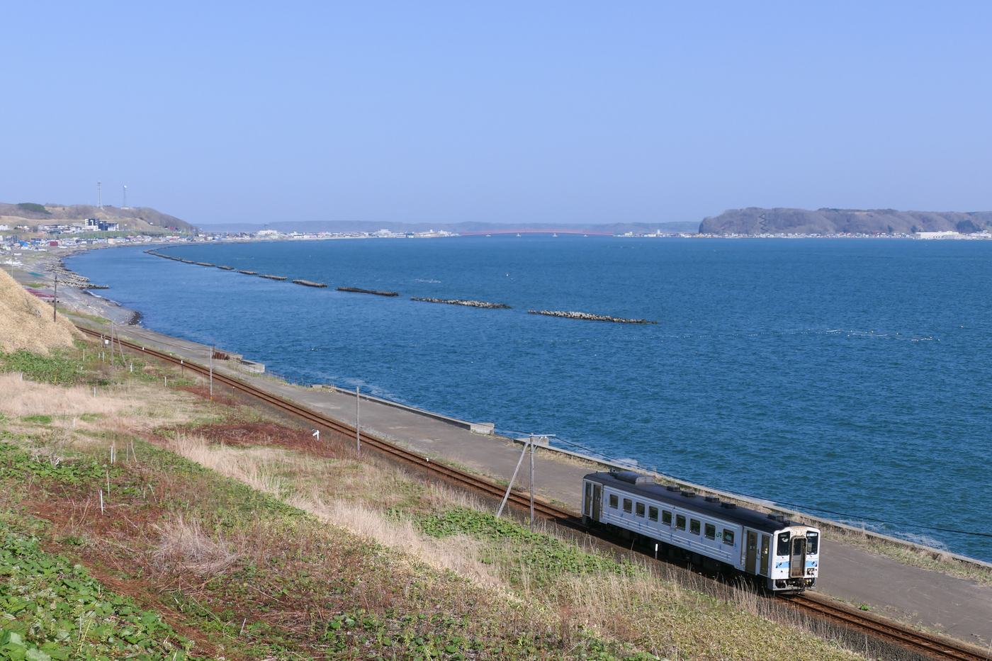 A single-car KiHa 54 diesel railcar on the Hanasaki Line running along the eastern Hokkaido coastline