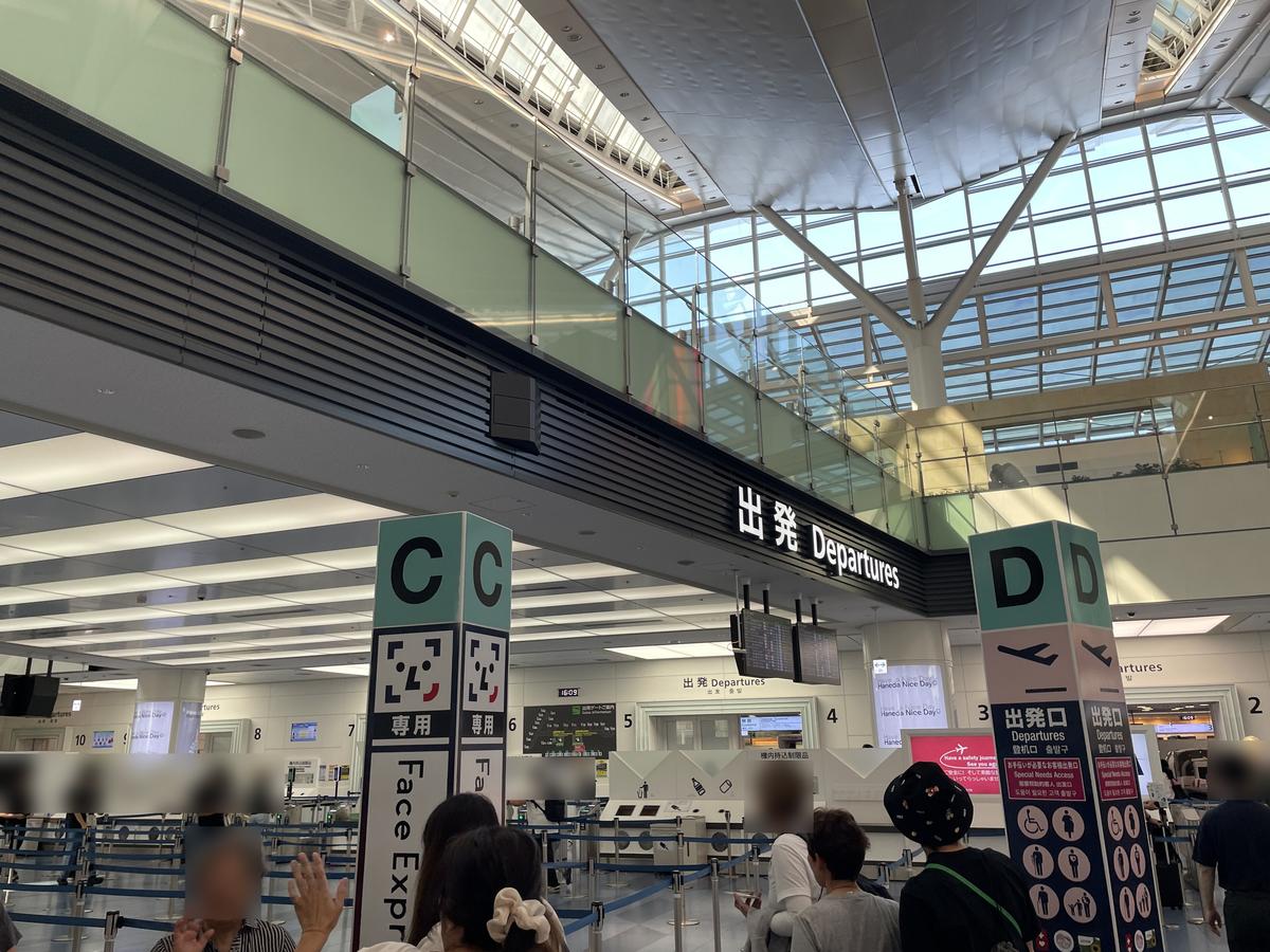羽田機場第 3 航廈的「出発 Departures」出發口:左邊 C 區柱子上印著笑臉圖示與「専用」「Face Express」,右邊 D 區柱子寫「出発口 Departures」,前方排隊的旅客臉部已模糊