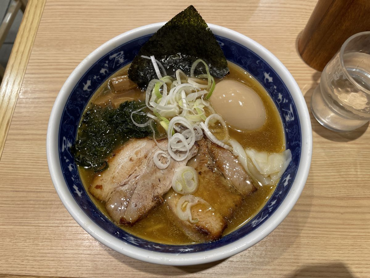 せたが屋羽田第 3 航廈店的拉麵:藍白花紋碗裡有三片叉燒、一顆滷蛋、海苔、海帶芽和蔥絲
