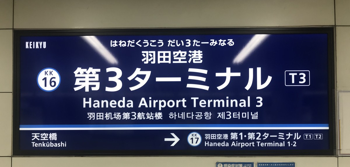 京急羽田空港第 3 航廈站的藍底站名牌：大字「羽田空港 第3ターミナル」、站號 KK16 與 T3 標誌，下方左邊是前一站「天空橋」，右邊箭頭指向「第1・第2ターミナル」