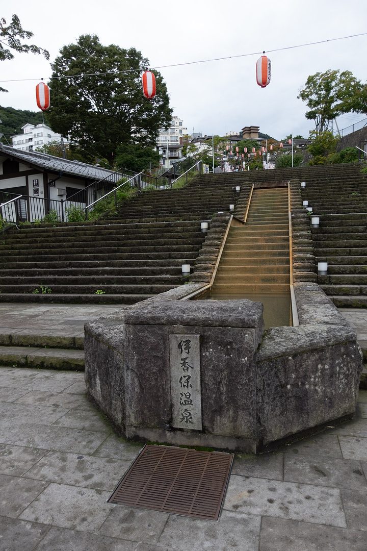 伊香保石段街最下方的廣場，刻著「伊香保溫泉」的石碑旁有一道石槽引著溫泉水順階而下，上空掛著紅白燈籠