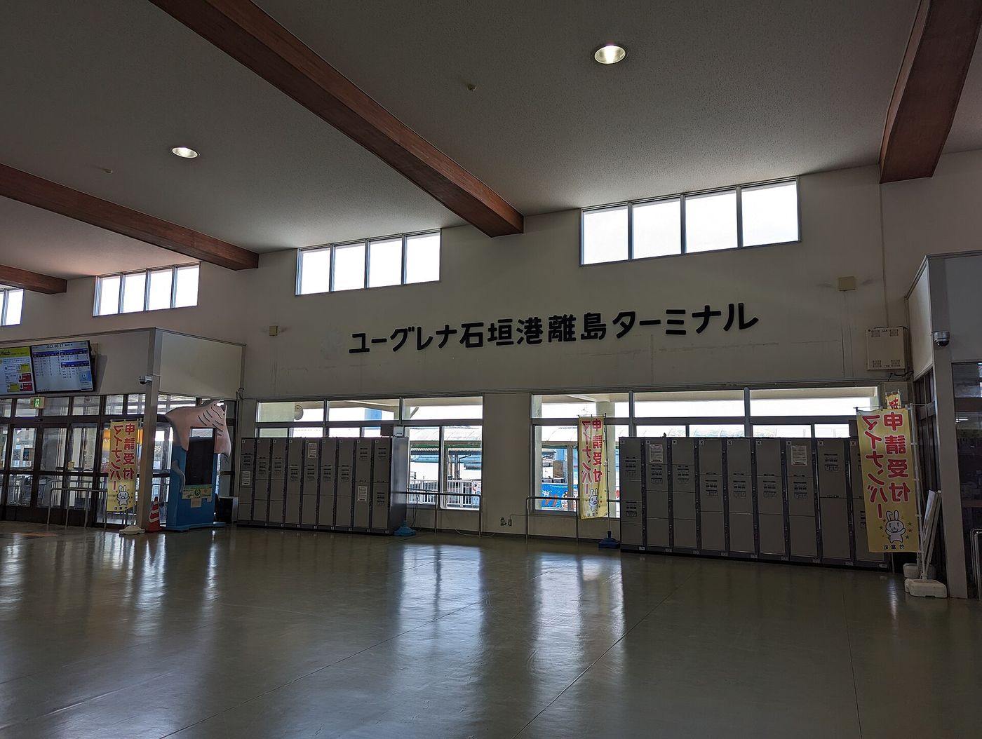 Concourse of the Euglena Ishigaki Port Remote Island Terminal, coin lockers along the wall and a departure board at the upper left