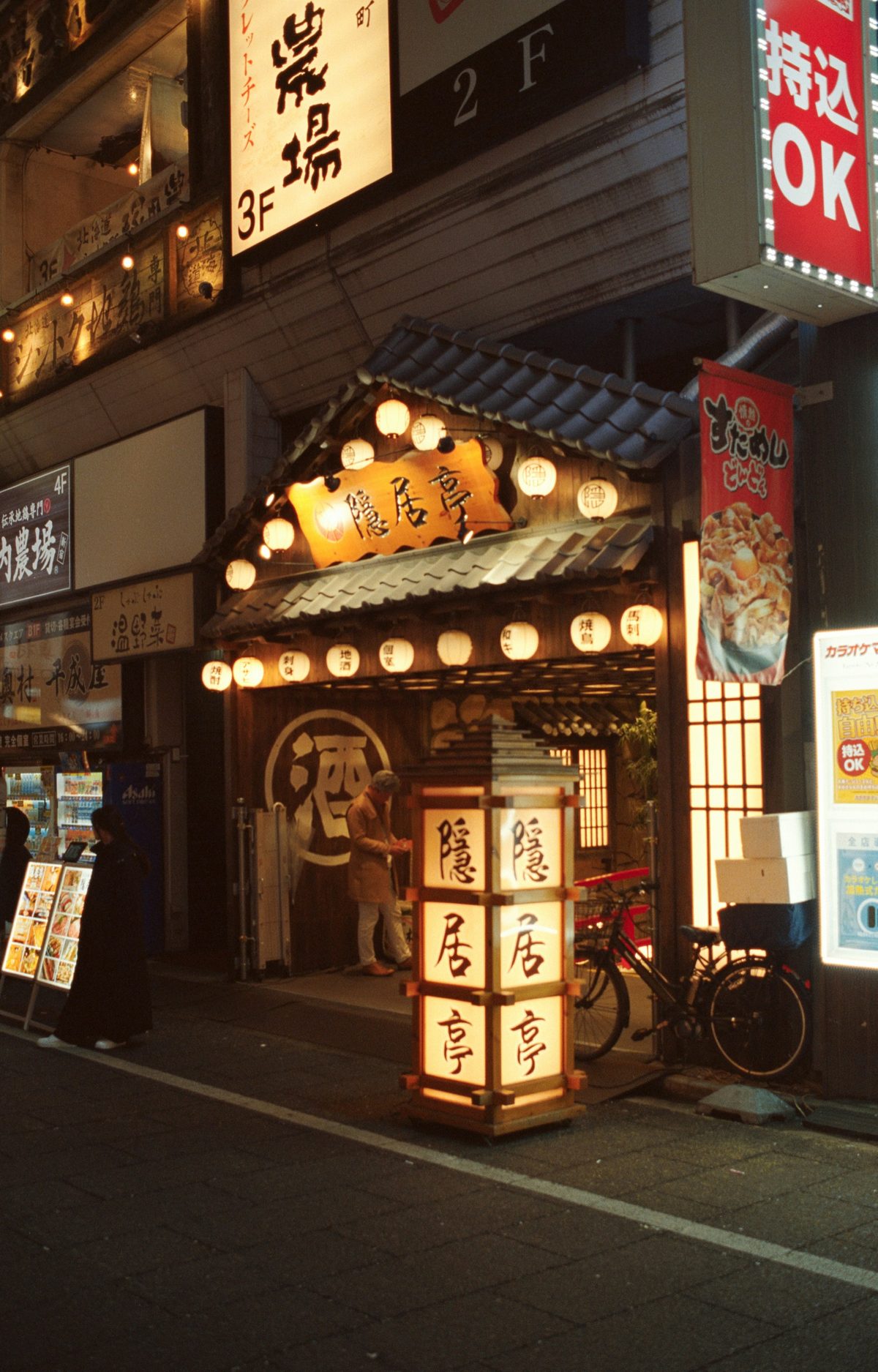 Pontocho izakaya alley at night: lantern-lit stone path lined with traditional wooden shopfronts