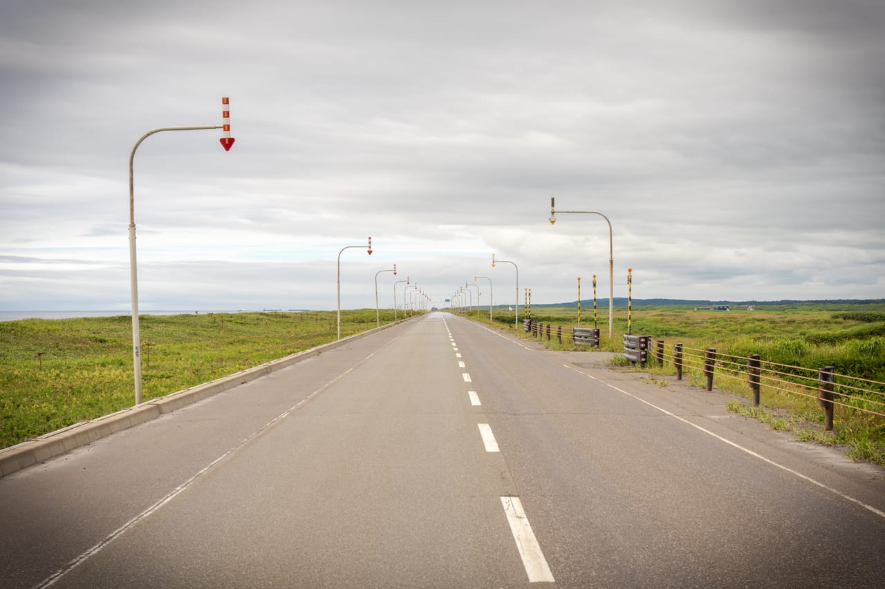 A straight open road through the wide plains of Hokkaido