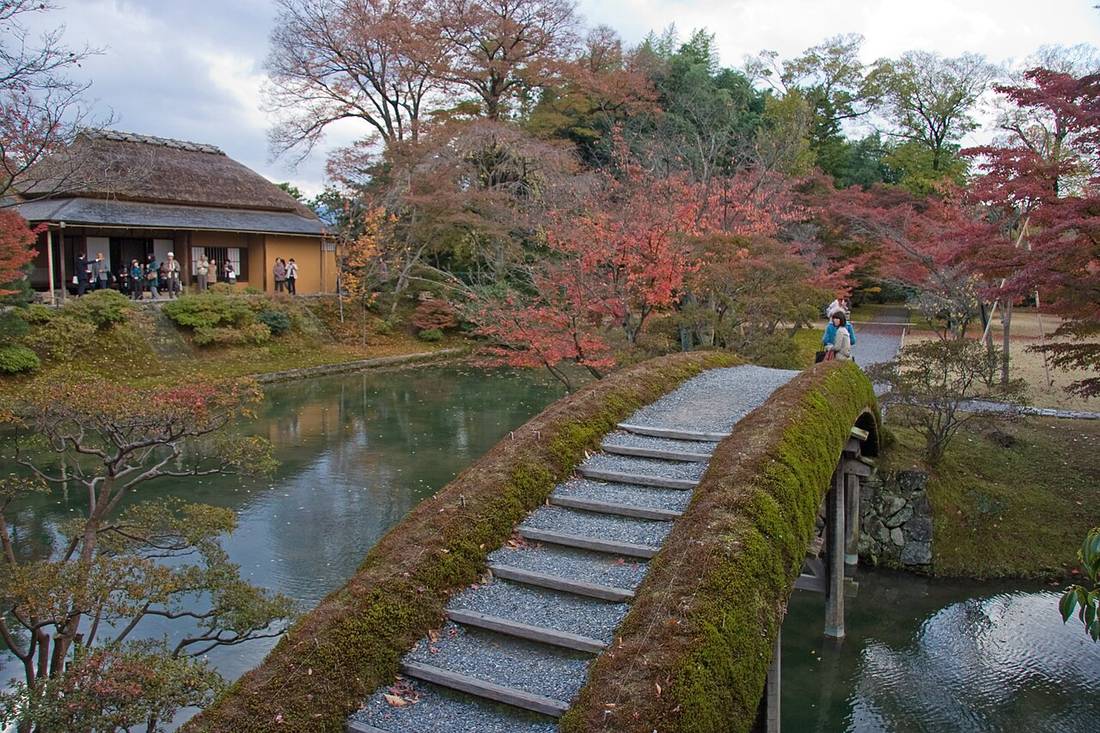 桂離宮池上一座拱起的土橋，橋面鋪碎石並有一階一階的木條，兩側長滿青苔、沒有扶手，對岸是茅葺屋頂的茶屋
