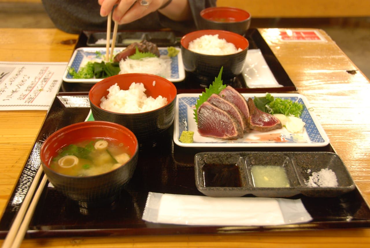 ひろめ市場的かつおのたたき稻燒鰹魚半敲燒，配蒜片與蔥