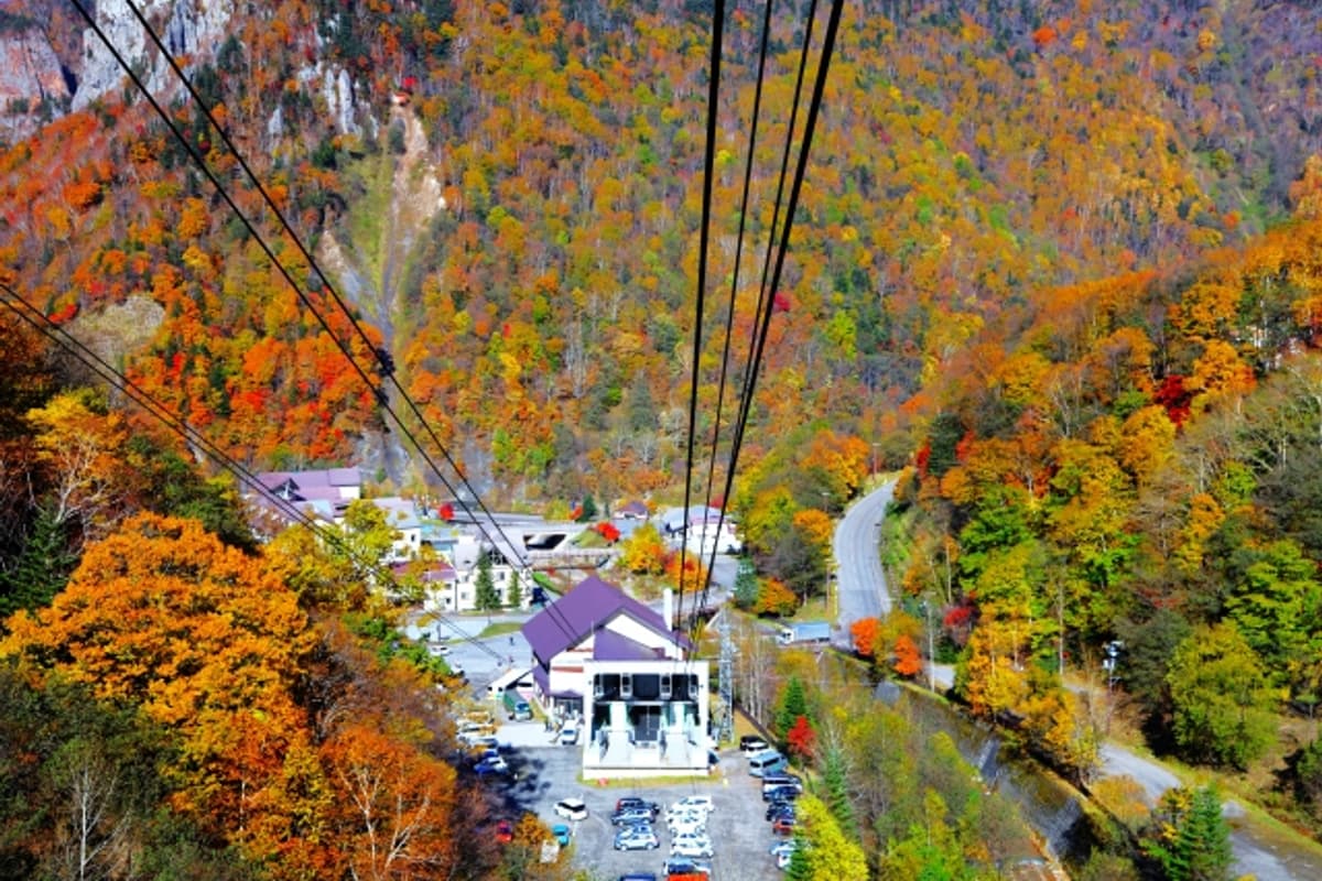 Sounkyo Onsen town and the Ishikari River gorge seen from the Kurodake Ropeway, framed by columnar cliff walls