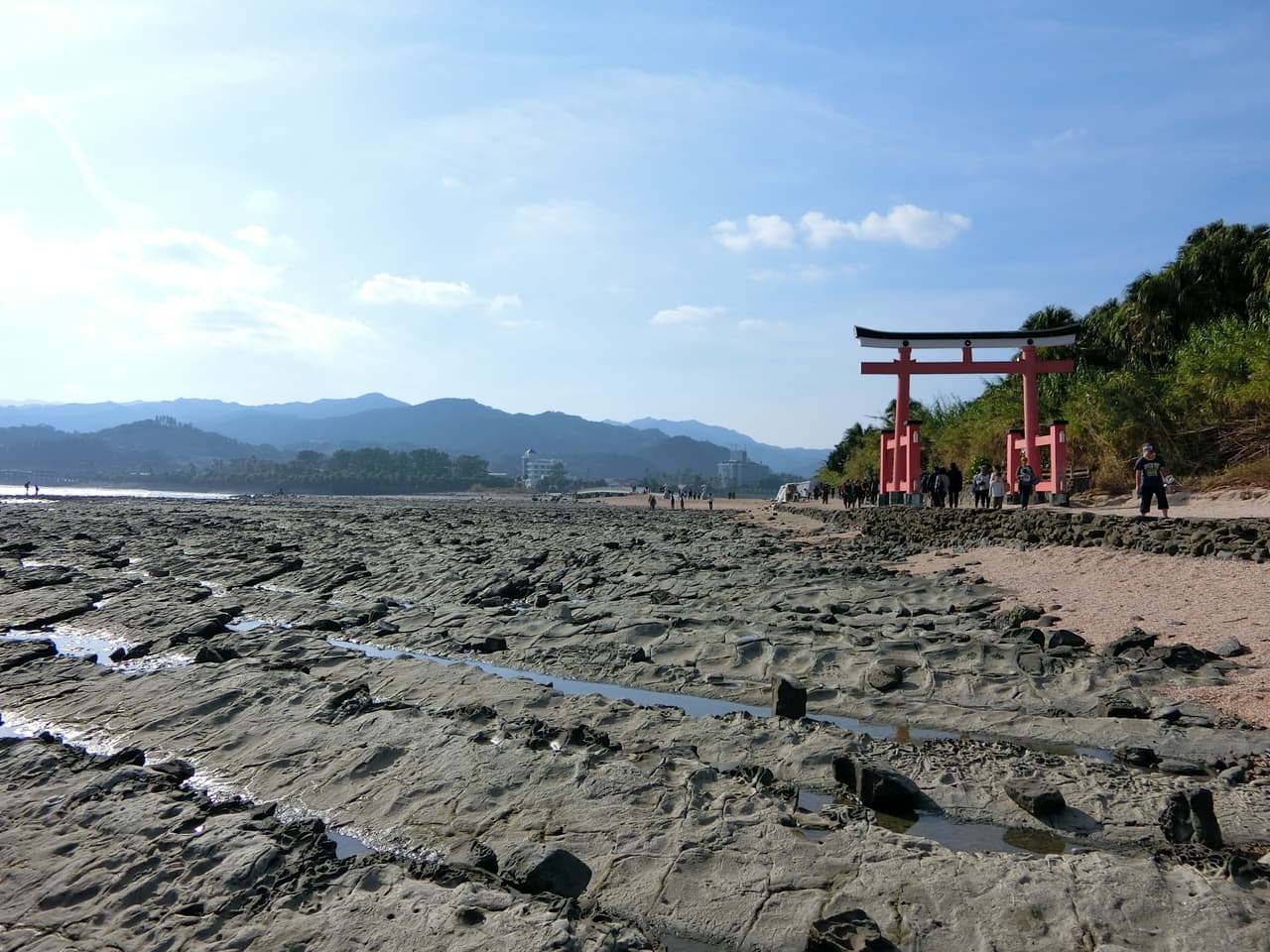 The Devil's Washboard wave-cut rock platform stretching out to sea with a torii at Aoshima, Miyazaki