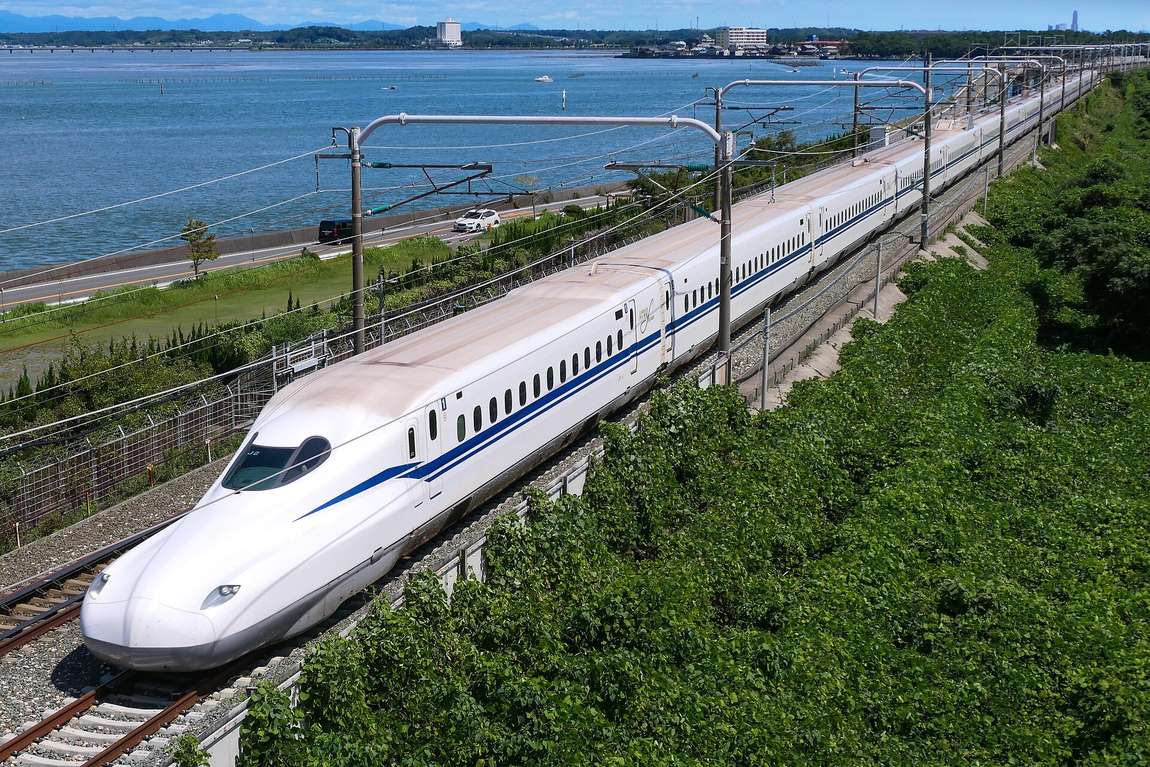An N700S series Tokaido Shinkansen train running on elevated track beside Lake Hamana