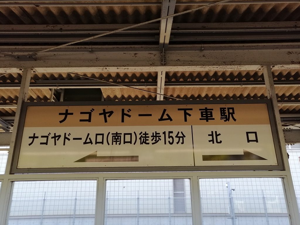JR 大曽根站月台的指示牌:上排寫「ナゴヤドーム下車駅」,下排左邊「ナゴヤドーム口(南口)徒歩15分」配向左箭頭,右邊「北口」配向右箭頭