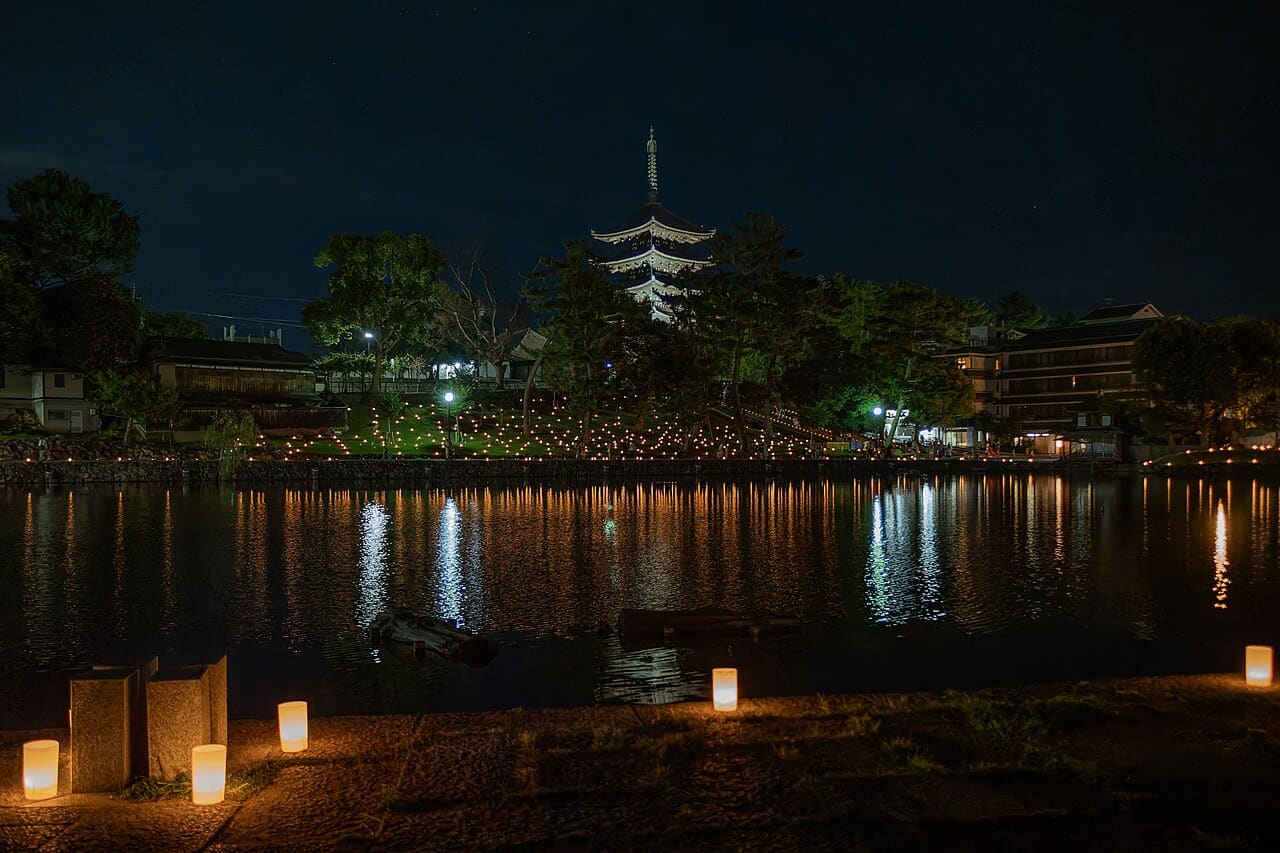 Nara Tokae festival at night, candles lining Sarusawa Pond with the illuminated five-storey pagoda of Kofukuji behind