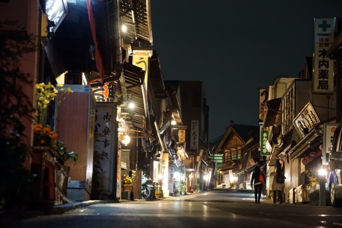 Naritasan Omotesando at night — stone pavement, wooden machiya houses, and lit lanterns even with shops closed