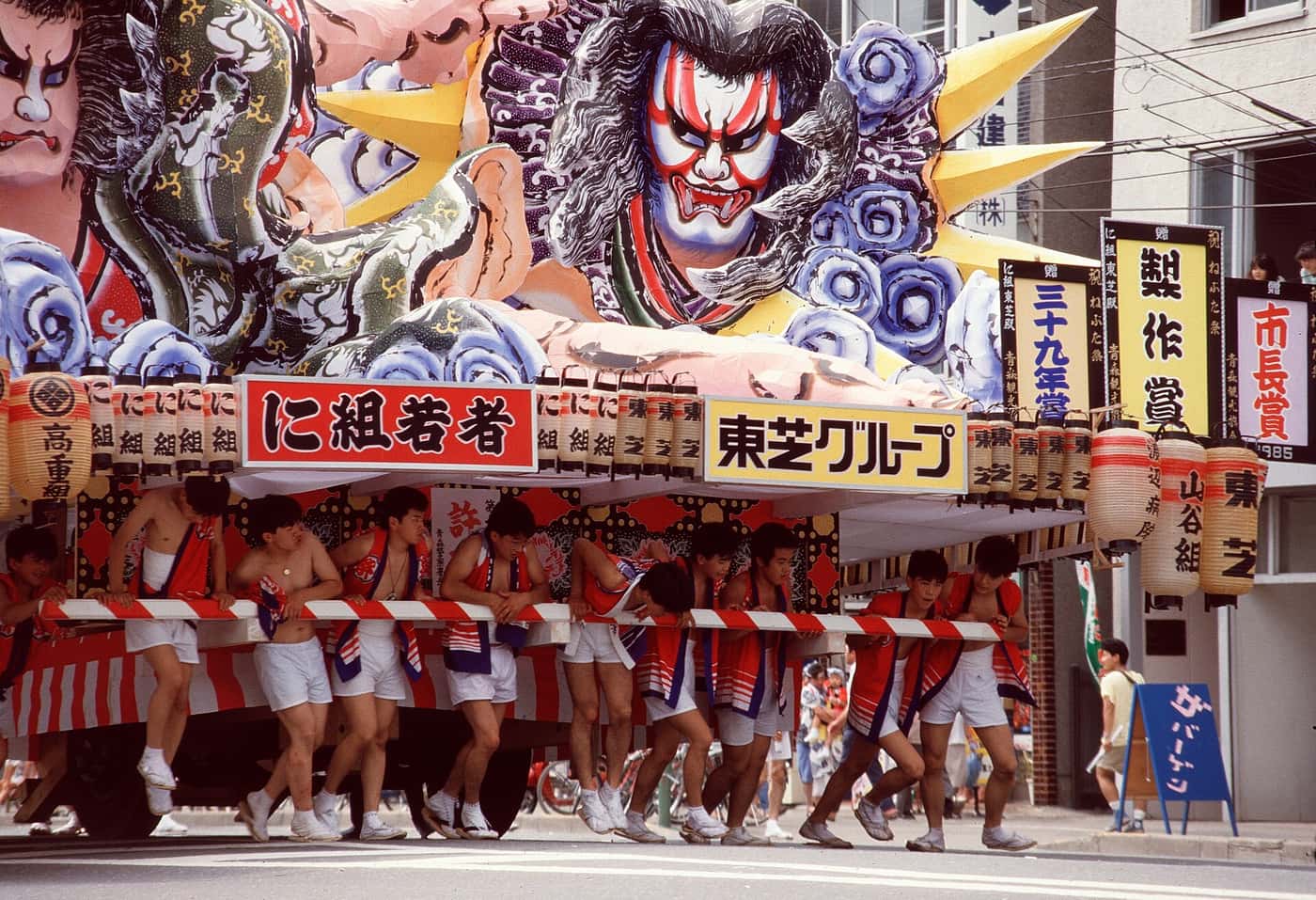 1985 年青森睡魔祭白天運行，曳き手推著掛有製作賞與市長賞受賞額的大型睡魔