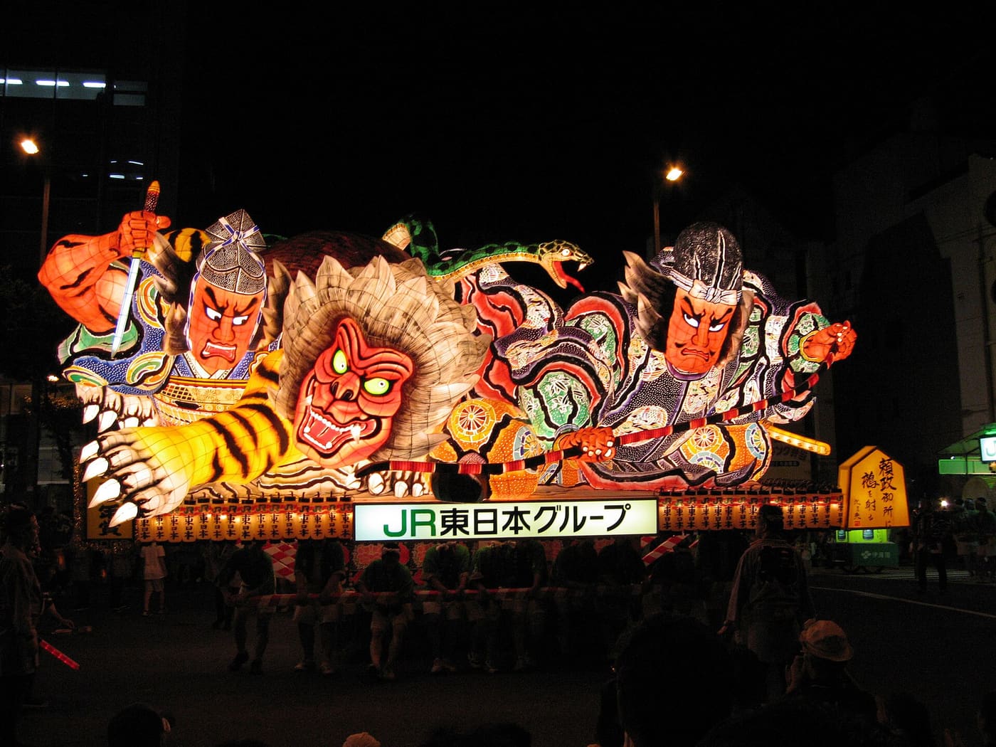 青森睡魔祭夜間運行中的大型睡魔，數公尺高的立體武者與猛虎人形燈籠在夜空下發光