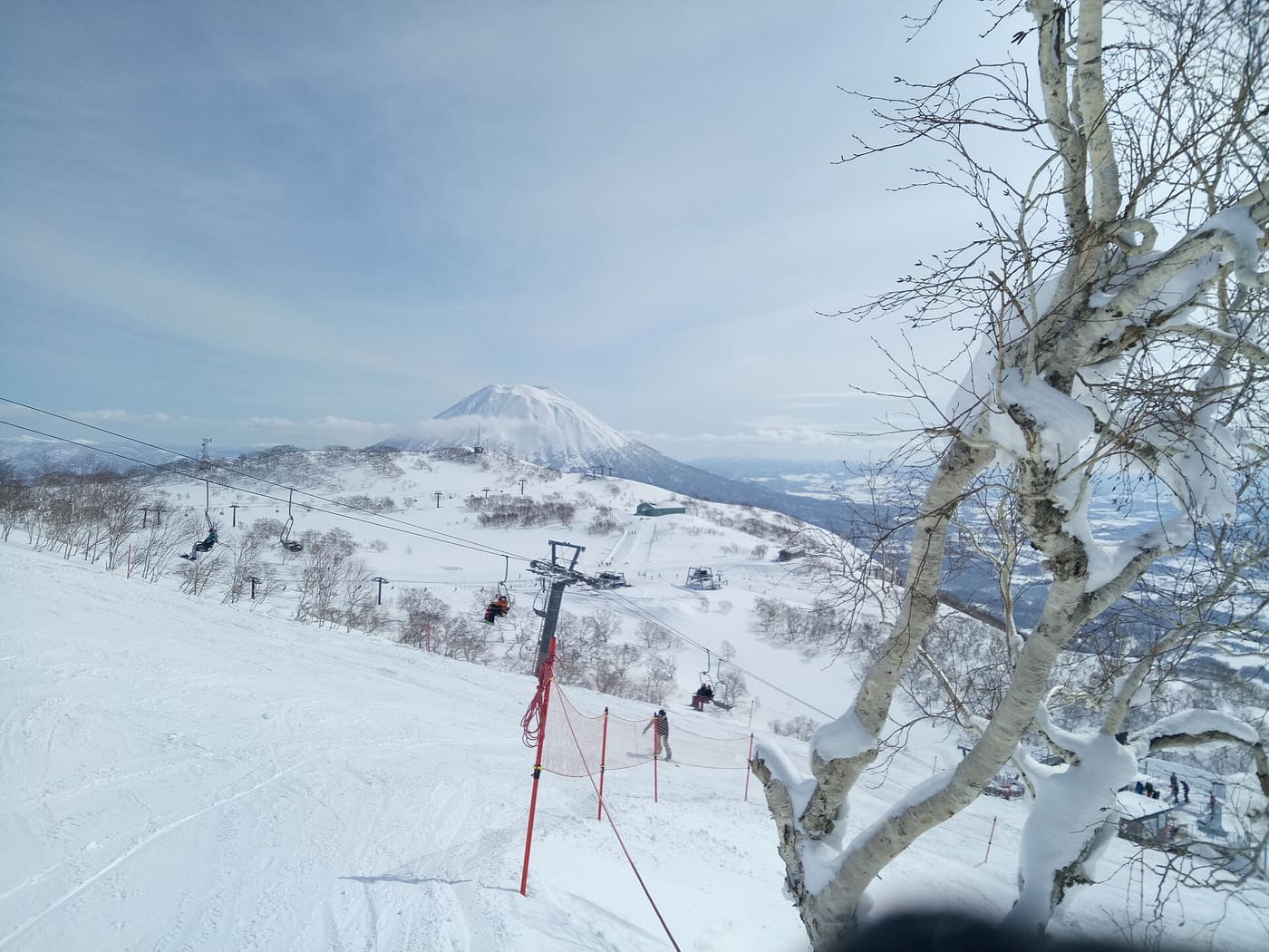 Groomed piste and chairlift at Niseko in Hokkaido, with Mount Yotei in the background