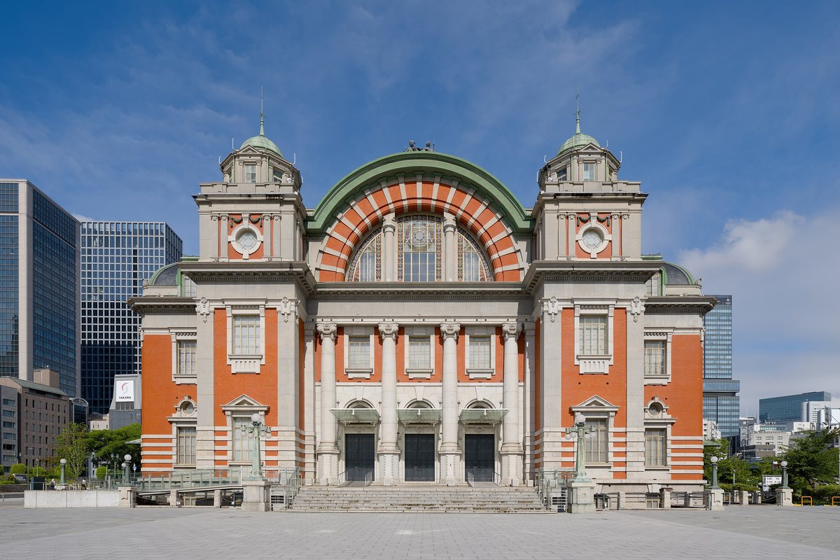 The red-brick and stone main facade of Osaka City Central Public Hall shot head-on from its forecourt on a clear day