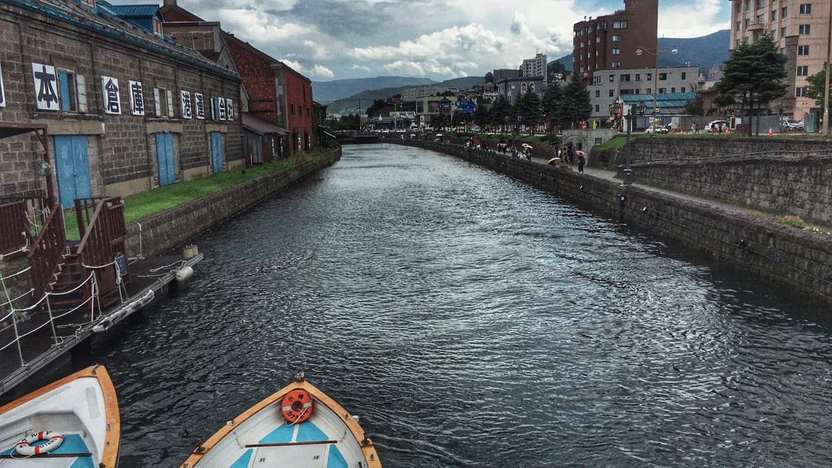 小樽運河冬季：石板路旁的舊倉庫與雪覆蓋的運河水面