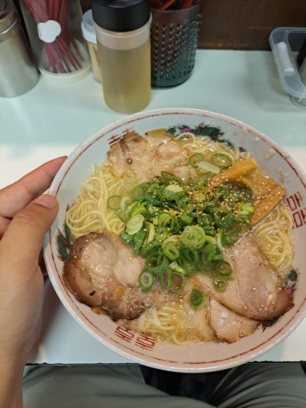 一碗鹽味拉麵，清澈金黃湯底配叉燒、玉米與蔥