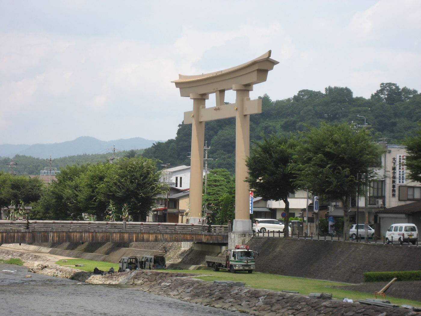 The great stone torii of Sakurayama Hachimangu shrine spanning the riverside road in Takayama