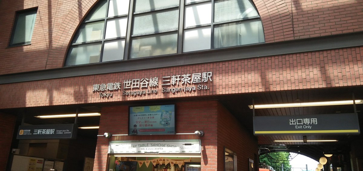 東急世田谷線三軒茶屋站的紅磚站房正面:半圓形大窗下方有「東急電鉄 世田谷線 三軒茶屋駅」的立體字,左側屋簷下掛著「三軒茶屋駅」站名牌,右側掛著「出口専用 Exit Only」的牌子,右下角露出一截橘色電車
