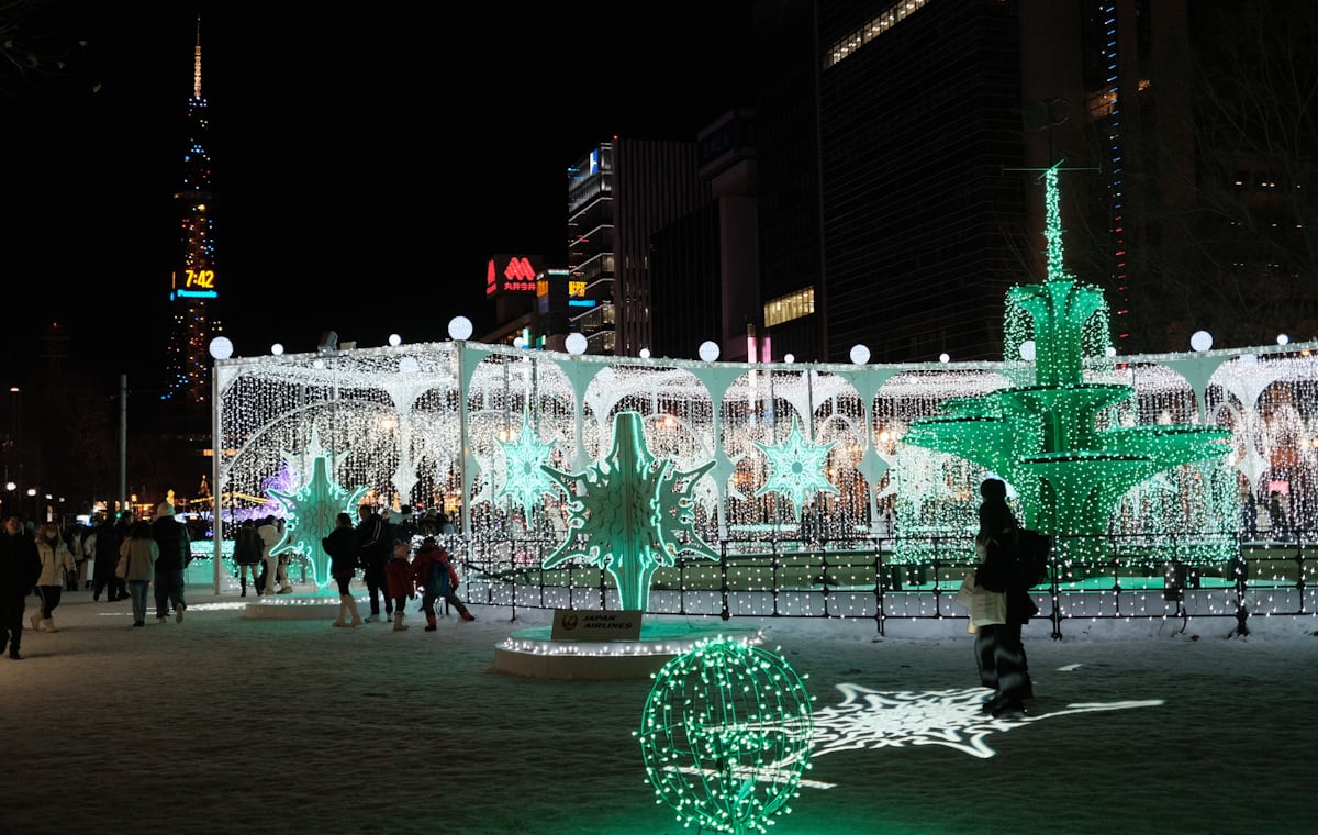 Odori Park at night in winter, visitors strolling along the lit walkway