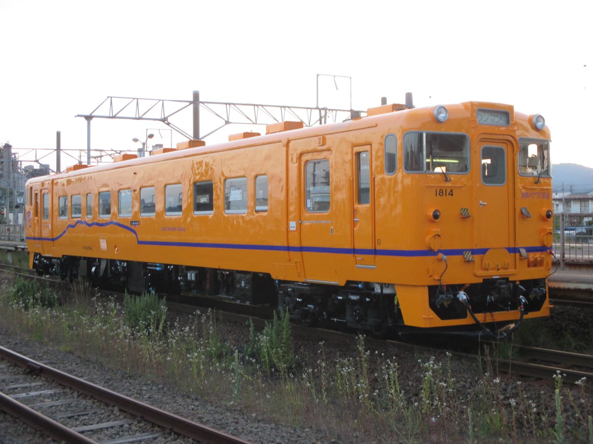 停在上磯站旁軌道上的道南いさりび鐵道キハ40形柴油車：單節橘黃色車身、藍色波浪腰帶，車頭上方顯示「ワンマン」