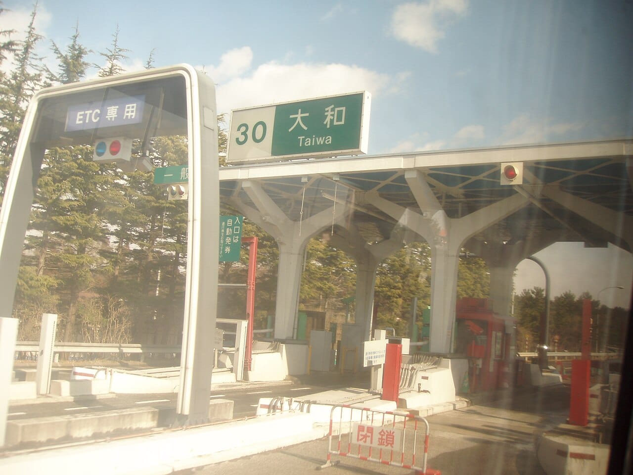 An ETC-only expressway toll gate in Japan with an overhead route sign
