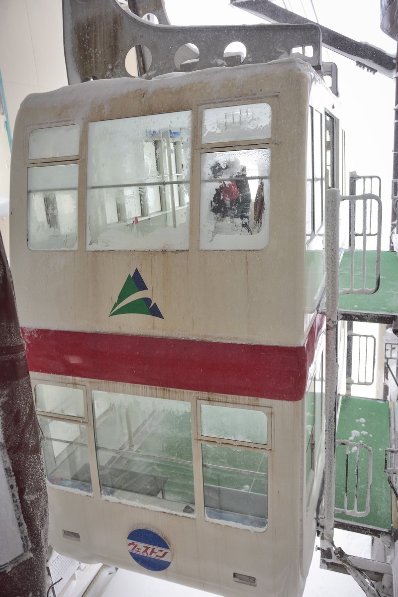第 2 纜車的雙層車廂停在月台邊,整個車體結滿白霜、車窗糊成一片,車門下方貼著藍色的「ウェストン」圓形標誌