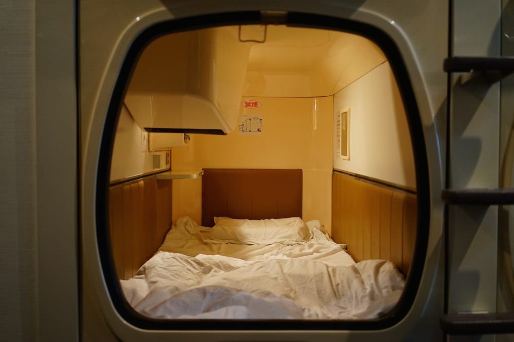 A single capsule pod bed in a Tokyo capsule hotel, the cheapest central accommodation option for solo travelers