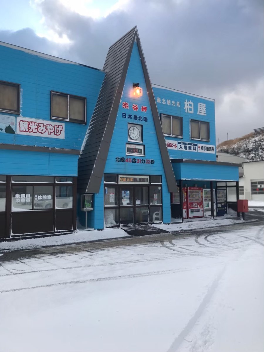 宗谷岬柏屋的藍色三角屋頂建築,牆上寫著「宗谷岬 日本最北端」和「北緯45度31分22秒」,時鐘下的電子溫度計顯示 -3.3℃,門前地面積雪,陰天