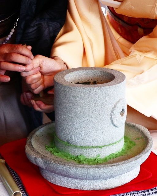 雙手轉動石臼研磨抹茶，綠色粉末緩緩堆出