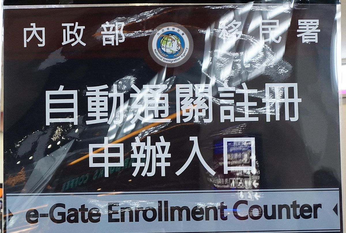 桃園機場第一航廈的移民署立牌,寫著「內政部移民署 自動通關註冊申辦入口 e-Gate Enrollment Counter」