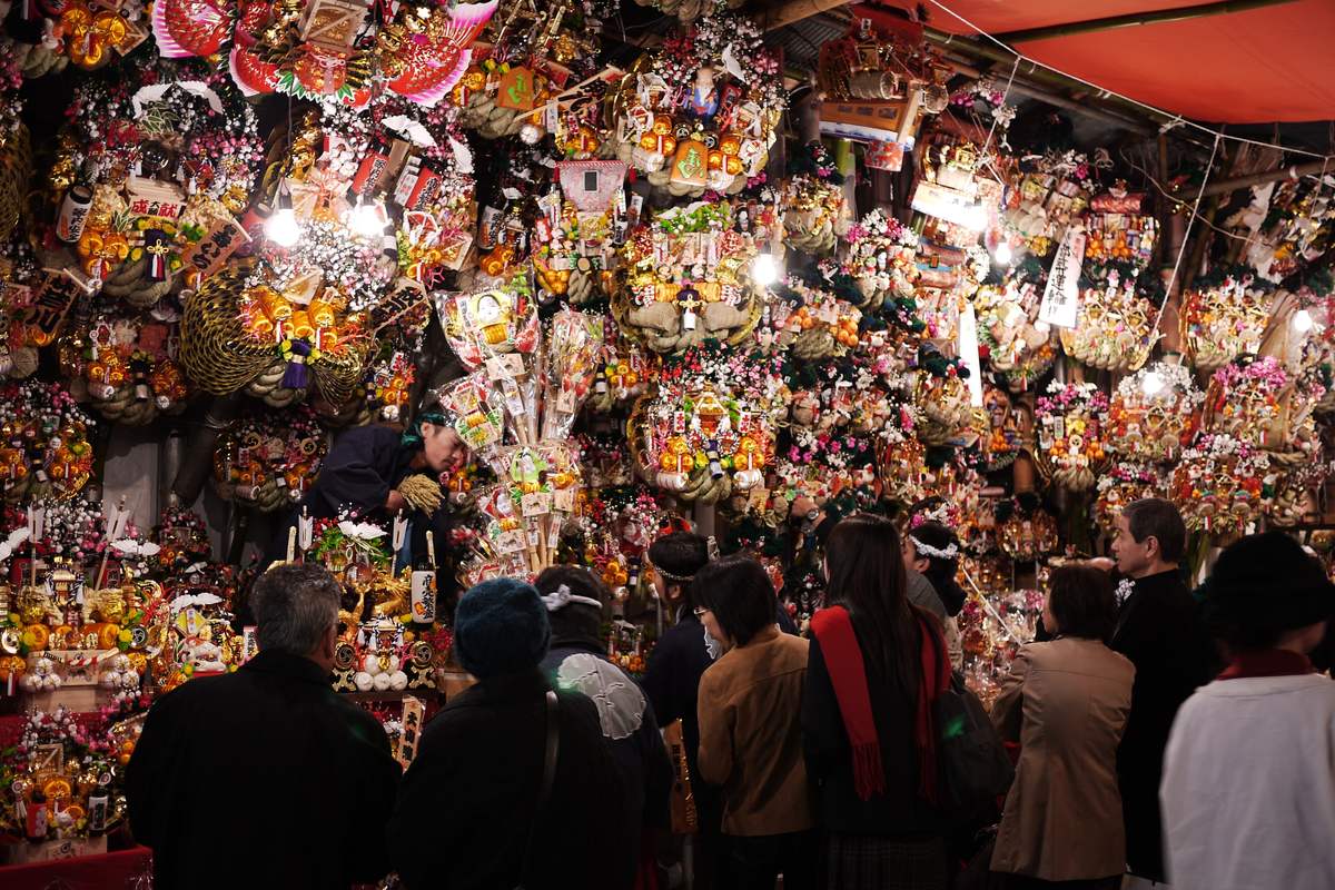 A Tori no Ichi stall hung wall-to-wall with kumade rakes of every size, decorated with gold coins, rice bales and lucky-god masks